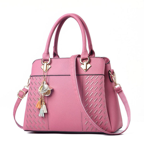 Pink handbag with decorative charms on a white background