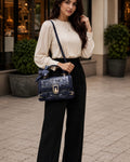 Woman holding a blue handbag in an urban setting