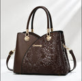 Brown handbag with gold accents on a white background