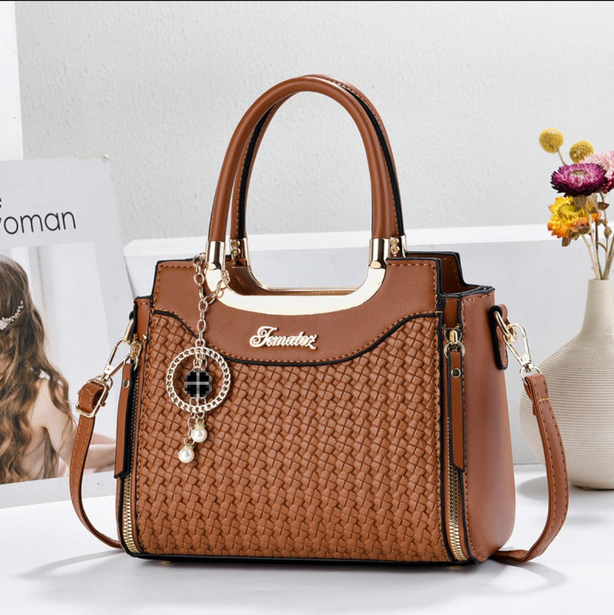 Brown handbag with gold accents on a white surface