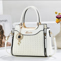 White handbag with gold accents on a light gray background
