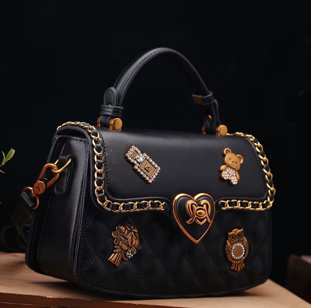 Black handbag with decorative charms on a dark background