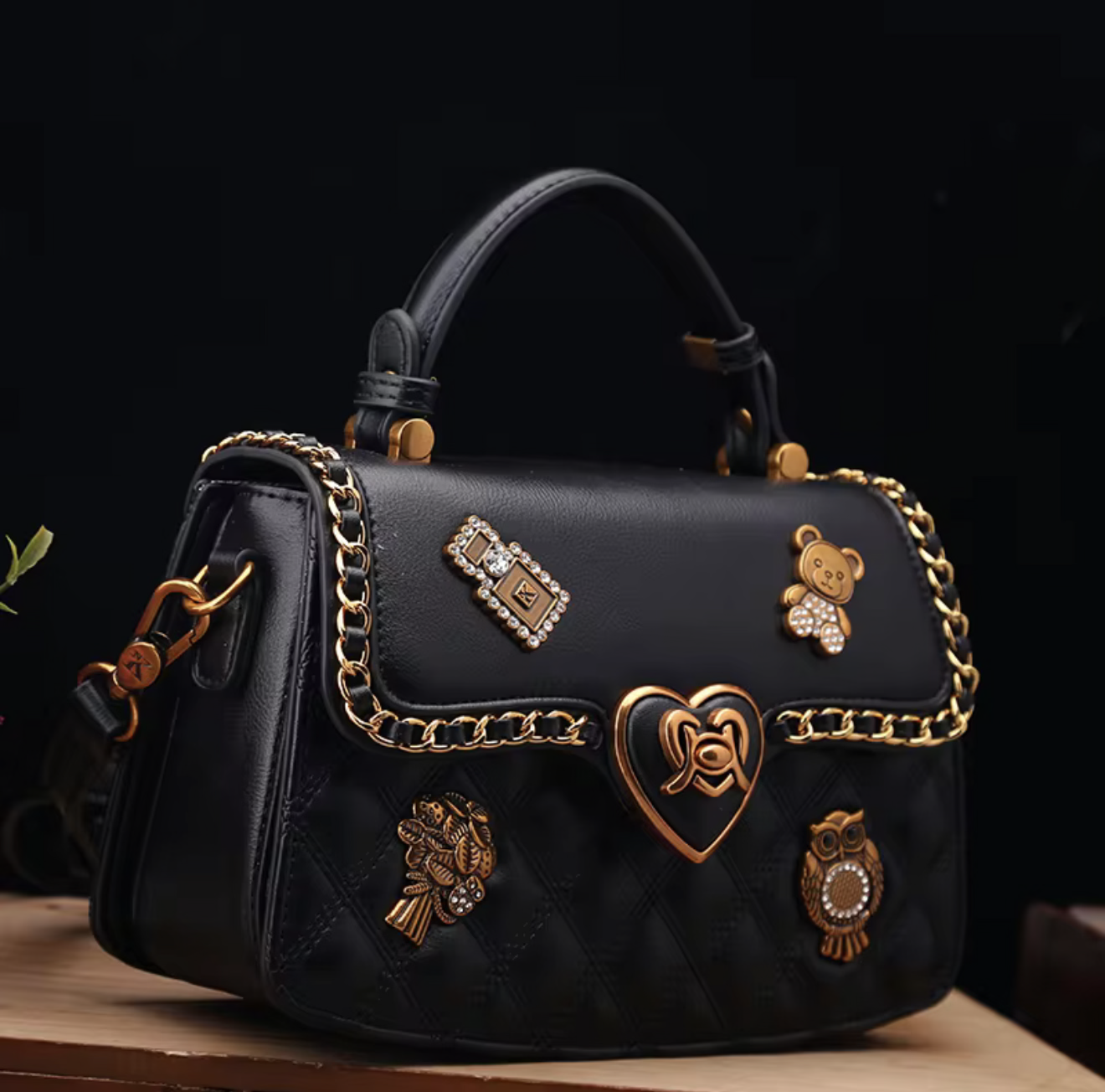 Black handbag with decorative charms on a dark background